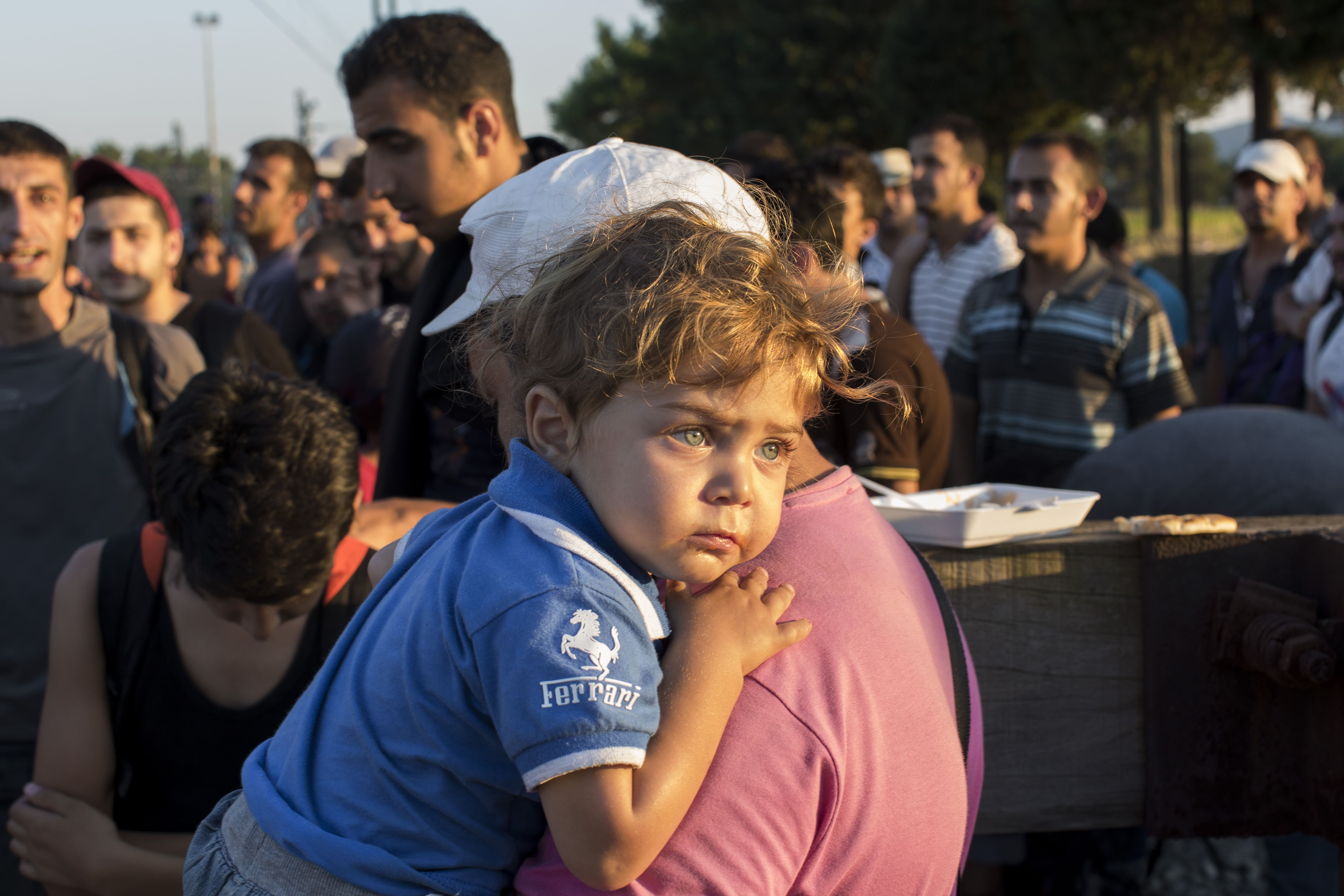 greece_a-syrian-refugee-holds-his-son