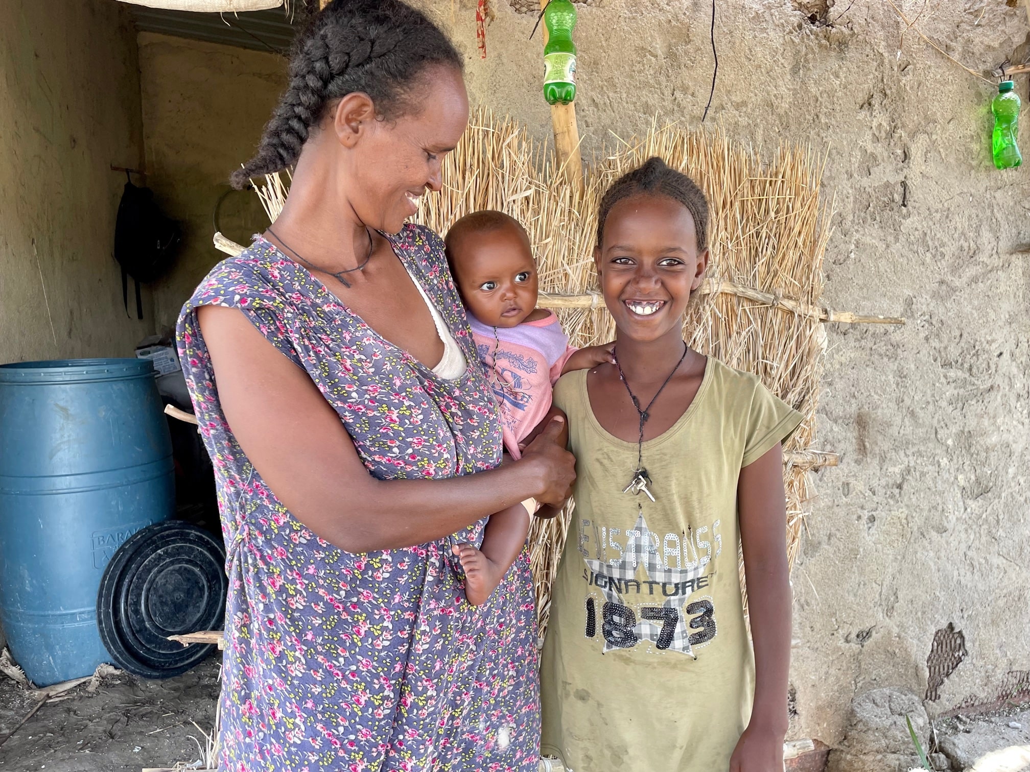 Sudan_Letha-Eymaret-and-baby-Madher-stand-outside-their-home